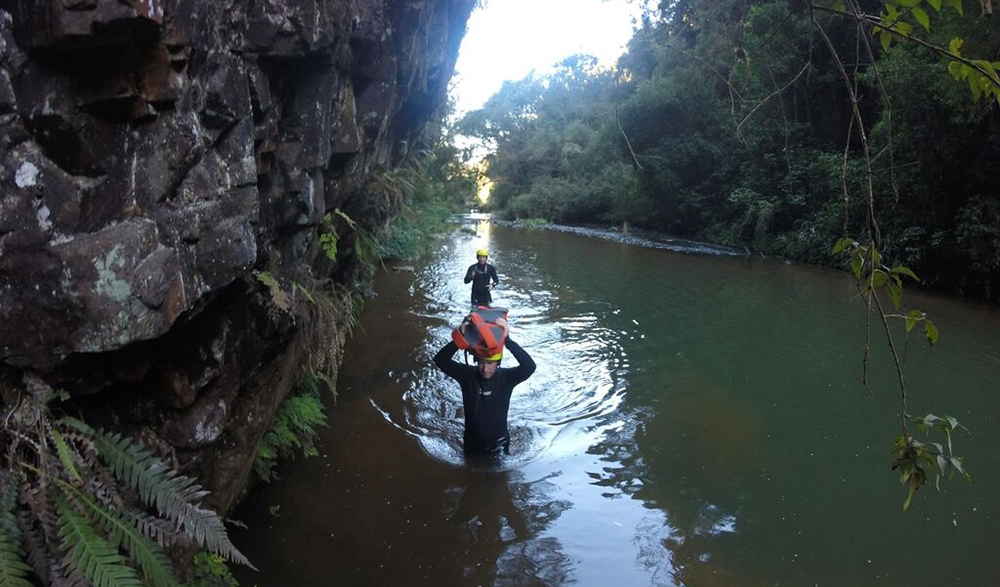 Sam wades through the river, whilst keeping the camera safe and dry. 