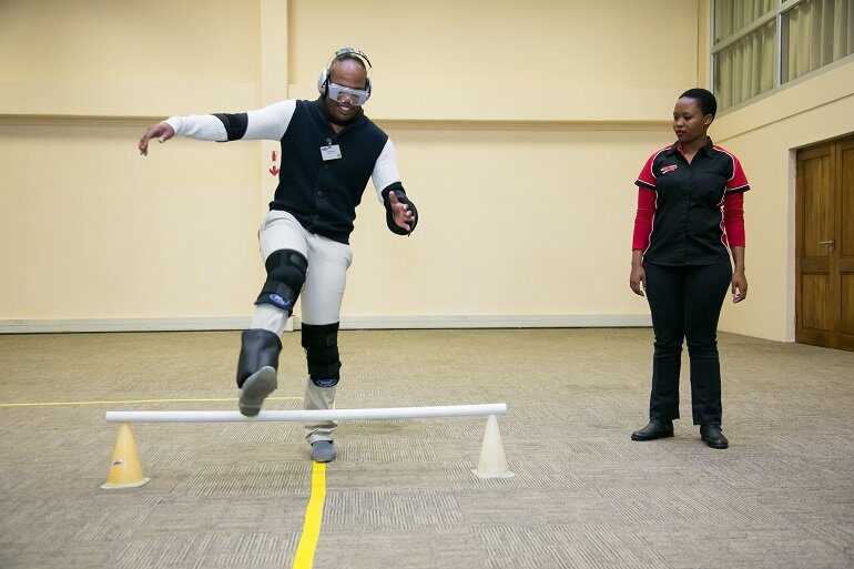 (Left) Ethol Mohale tries on the Drunk Suit as Derek Kirkby, Ford’s Driving Skills For Life training director in South Africa, explains the fascinating story behind the development of the suit by the Meyer-Hentschel Institute in Germany. (Right) A sober Gino Shelile from Ignition TV, stumbles as he demonstrates the effects of the Drunk Suit while trying to complete a simple walking exercise while Ethol Mohale from Ford’s Driving Skills For Life programme looks on. (Left) Ethol Mohale tries on the Drunk Suit as Derek Kirkby, Ford’s Driving Skills For Life training director in South Africa, explains the fascinating story behind the development of the suit by the Meyer-Hentschel Institute in Germany. (Right) A sober Gino Shelile from Ignition TV, stumbles as he demonstrates the effects of the Drunk Suit while trying to complete a simple walking exercise while Ethol Mohale from Ford’s Driving Skills For Life programme looks on.